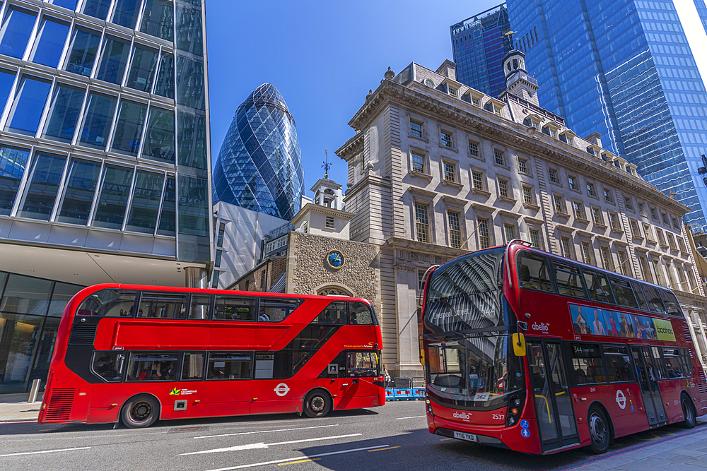 View of The Gherkin peaking between other contemporary architecture and red buses, City of London, London, England, United Kingdom, Europe