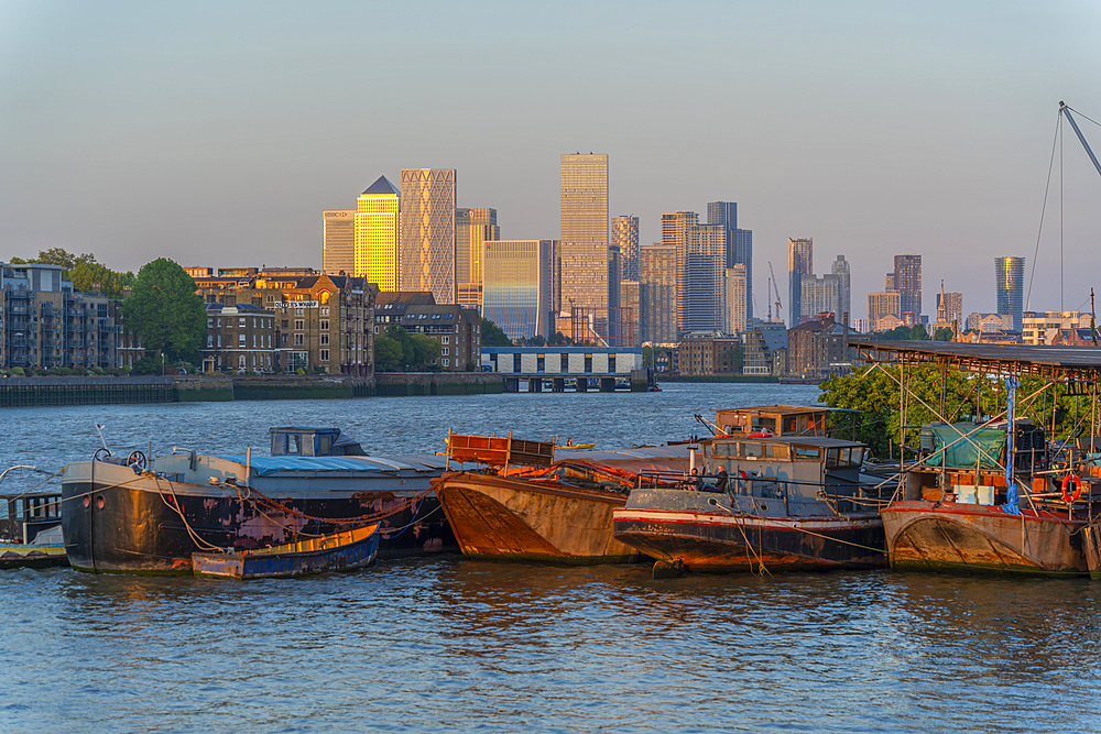 View of Thames barges, Docklands and Canary Wharf at sunset, London, England, United Kingdom, Europe