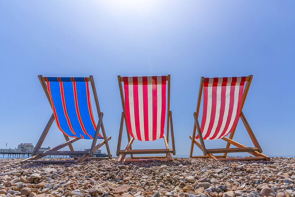 View of Worthing Pier and colourful deckchairs on Worthing Beach, Worthing, West Sussex, England, United Kingdom, Europe