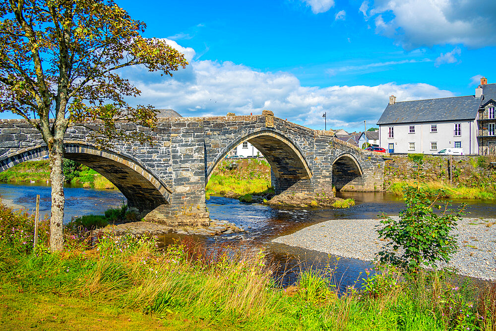 View of Pont Fawr (Inigo Jones Bridge) over Conwy River and riverside houses, Llanrwst, Clwyd, Snowdonia, North Wales, United Kingdom, Europe