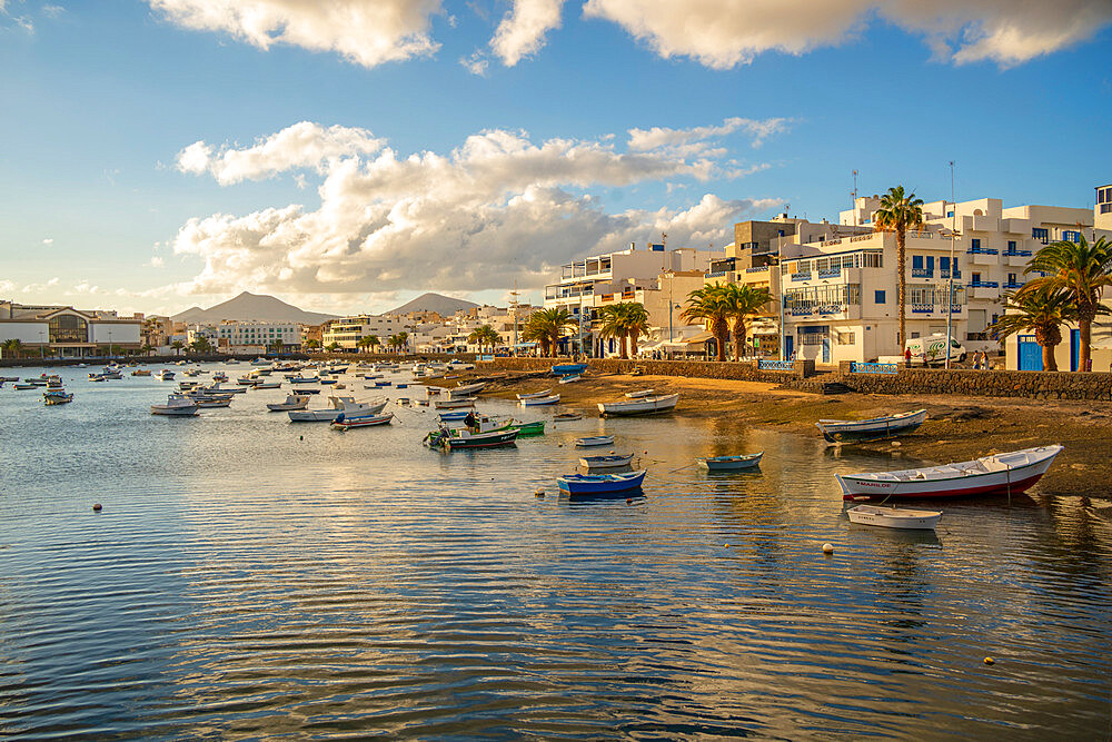 View of boats on beach in Baha de Arrecife Marina surrounded by shops, bars and restaurants at sunset, Arrecife, Lanzarote, Canary Islands, Spain, Atlantic, Europe