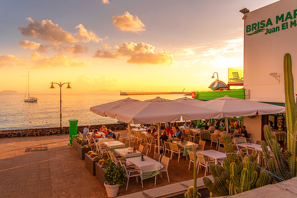 View of restaurant, sailboat on the sea and Fuerteventura in background at sunset, Playa Blanca, Lanzarote, Canary Islands, Spain, Atlantic, Europe