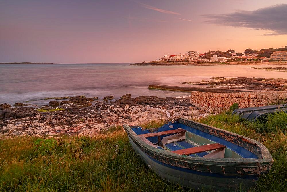 View of Playa Punta Prima and rowing boat at dusk, Punta Prima, Menorca, Balearic Islands, Spain, Europe