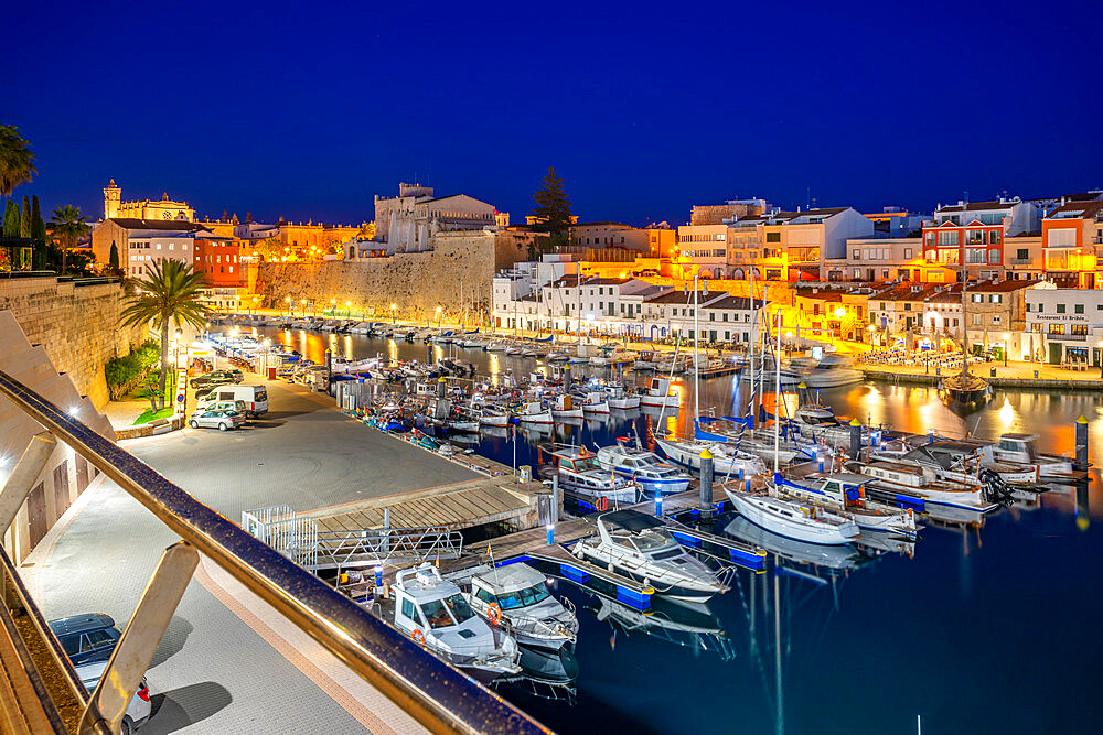 View of boats in marina overlooked by whitewashed buildings at dusk, Ciutadella, Menorca, Balearic Islands, Spain, Mediterranean, Europe