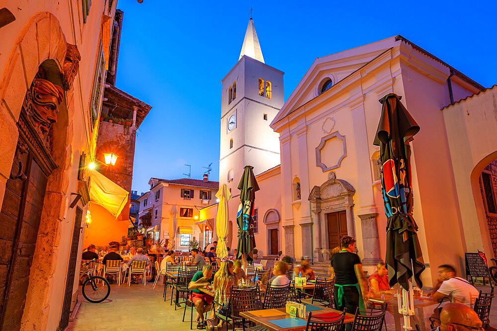 View of St. George's Church and alfresco eating at dusk in Lovran village, Lovran, Kvarner Bay, Eastern Istria, Croatia, Europe