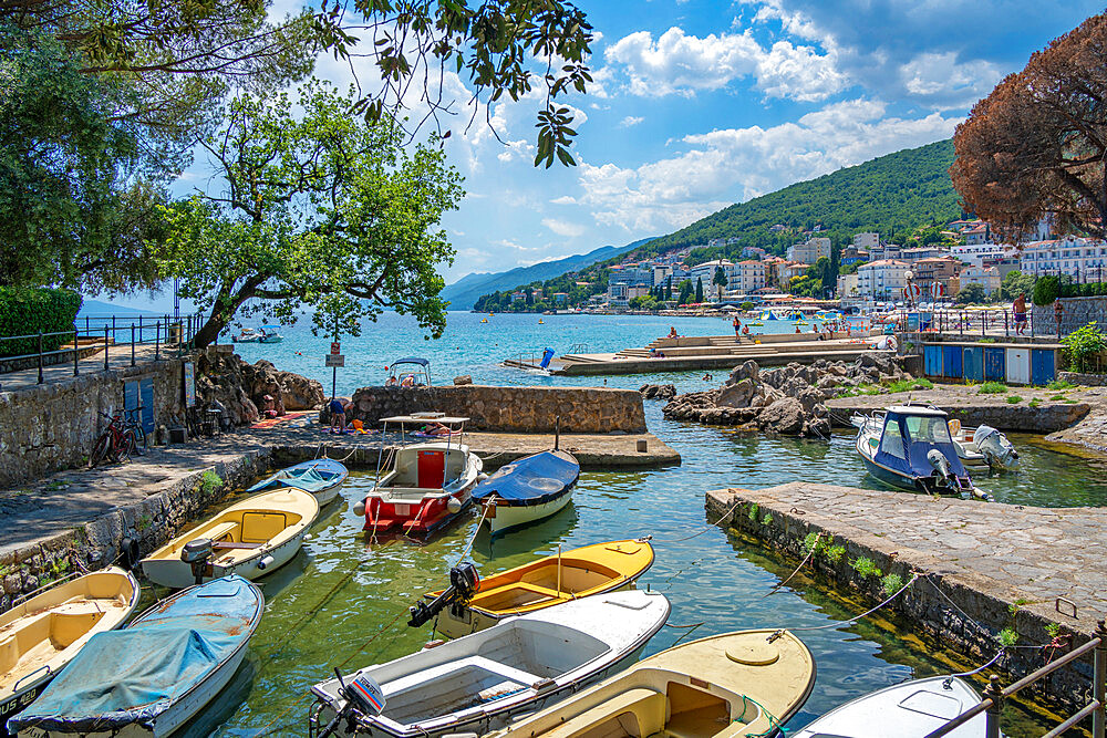 View of rocky inlet and boats with town of Opatija in background, Opatija, Kvarner Bay, Croatia, Europe