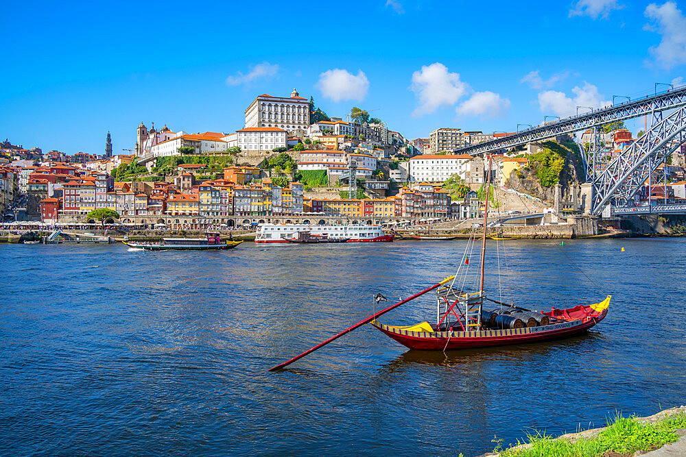 View of the Dom Luis I bridge over Douro River and Rabelo boat aligned with colourful buildings, UNESCO World Heritage Site, Porto, Norte, Portugal, Europe