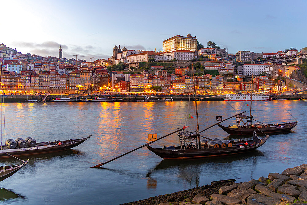 View of Douro River and Rabelo boats aligned with colourful buildings at dusk, Porto, Norte, Portugal, Europe