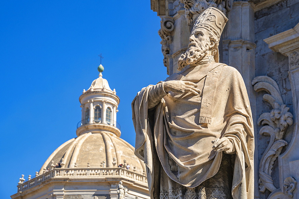 View of statue at the Duomo and Chiesa della Badia di Sant'Agata rotunda from Piazza Duomo, Catania, Sicily, Italy, Mediterranean, Europe