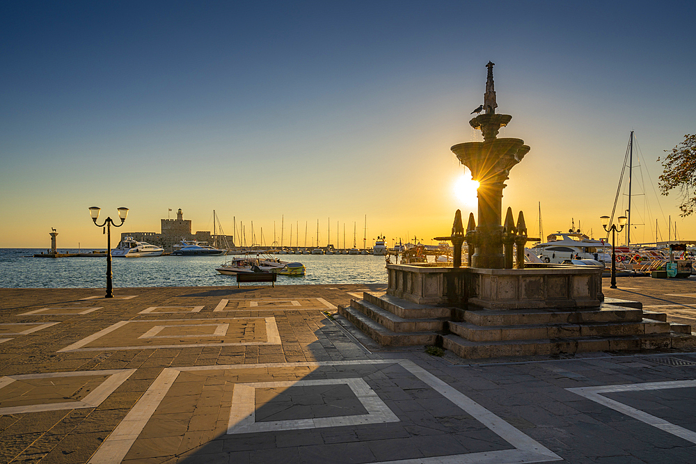 View of fountain and Saint Nicholas Fortress at sunrise, City of Rhodes, Rhodes, Dodecanese Islands, Greek Islands, Greece, Europe