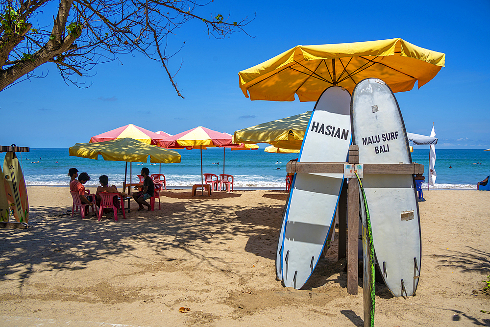 View of sunshades and surf boards on sunny morning on Kuta Beach, Kuta, Bali, Indonesia, South East Asia, Asia