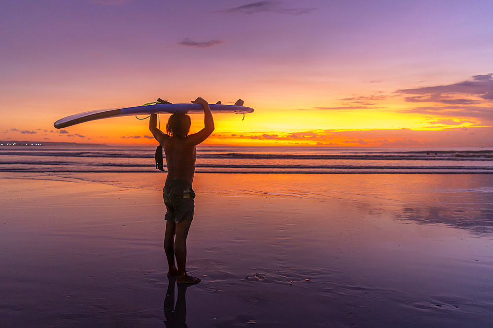 View of surfboarder on Kuta Beach at sunset, Kuta, Bali, Indonesia, South East Asia, Asia