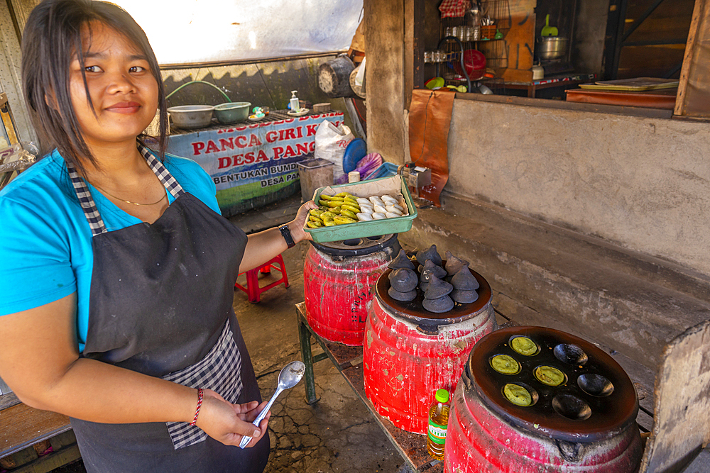 Girl making Klepon, traditional Balinese rice cakes, Bali, Indonesia, South East Asia, Asia