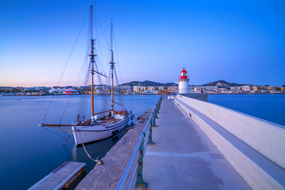 View of harbour lighthouse and sailing ship at dusk, UNESCO World Heritage Site, Ibiza Town, Eivissa, Balearic Islands, Spain, Mediterranean, Europe