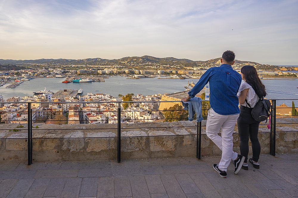 Couple with elevated view of harbour, Dalt Vila district and city defence walls, UNESCO World Heritage Site, Ibiza Town, Eivissa, Balearic Islands, Spain, Mediterranean, Europe