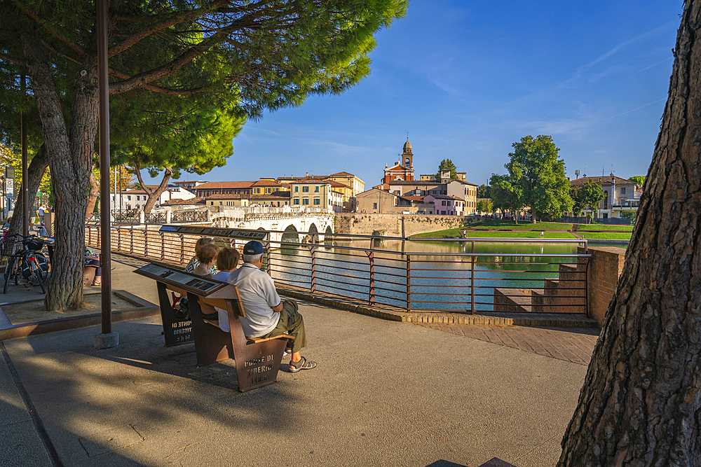 Locals viewing Ponte di Tiberio reflecting in Rimini Canal from Borgo San Giuliano, Rimini, Emilia-Romagna, Italy, Europe