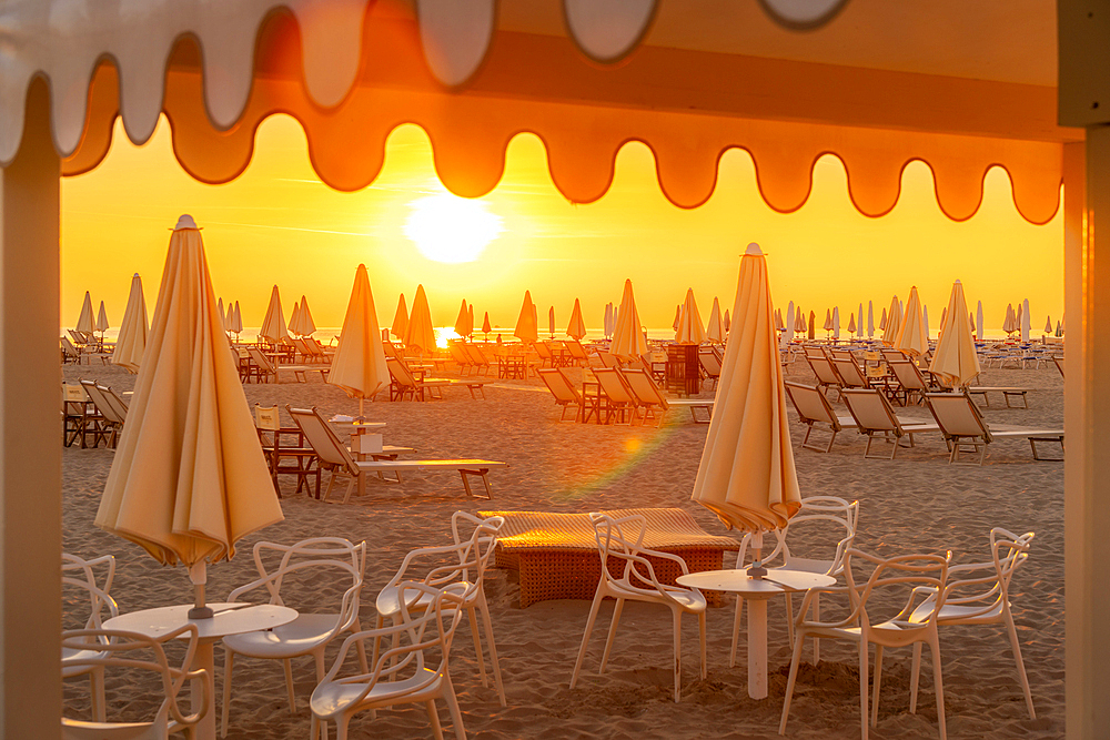 View of sunrise and sunshades on the Lido on Rimini Beach, Rimini, Emilia-Romagna, Italy, Europe