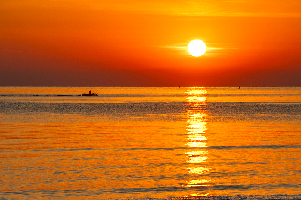 View of sunrise reflecting in the sea from Rimini Beach, Rimini, Emilia-Romagna, Italy, Europe