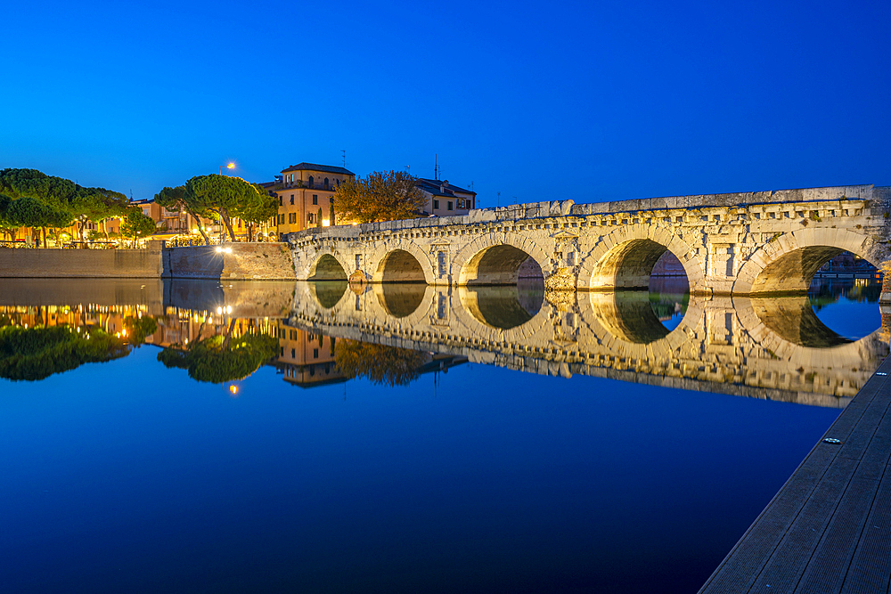 View of Ponte di Tiberio reflecting in Rimini Canal in Borgo San Giuliano district at dusk, Rimini, Emilia-Romagna, Italy, Europe