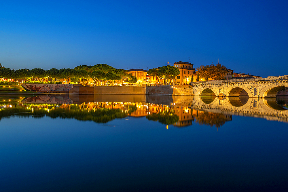 View of Ponte di Tiberio reflecting in Rimini Canal in Borgo San Giuliano district at dusk, Rimini, Emilia-Romagna, Italy, Europe