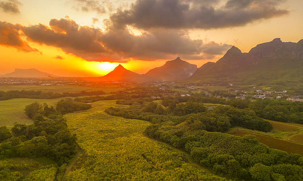 View of golden sunset behind Long Mountain and patchwork of green fields, Mauritius, Indian Ocean, Africa