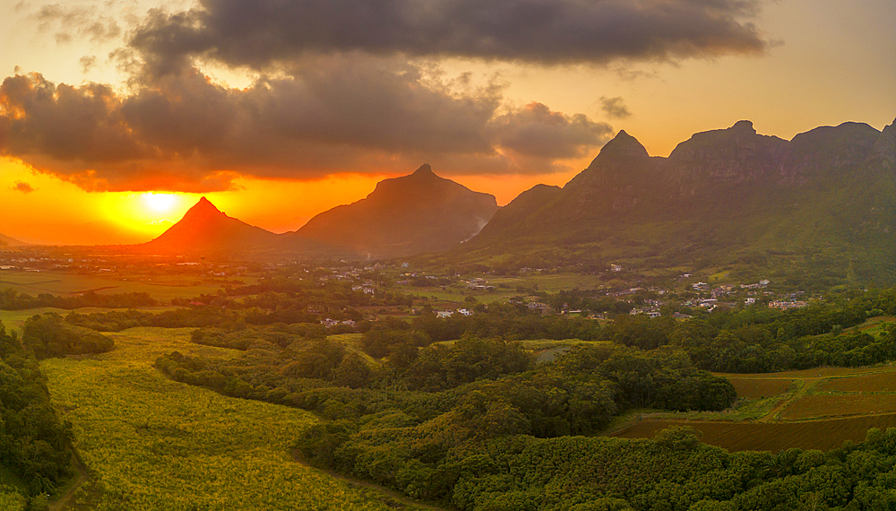 View of golden sunset behind Long Mountain and patchwork of green fields, Mauritius, Indian Ocean, Africa