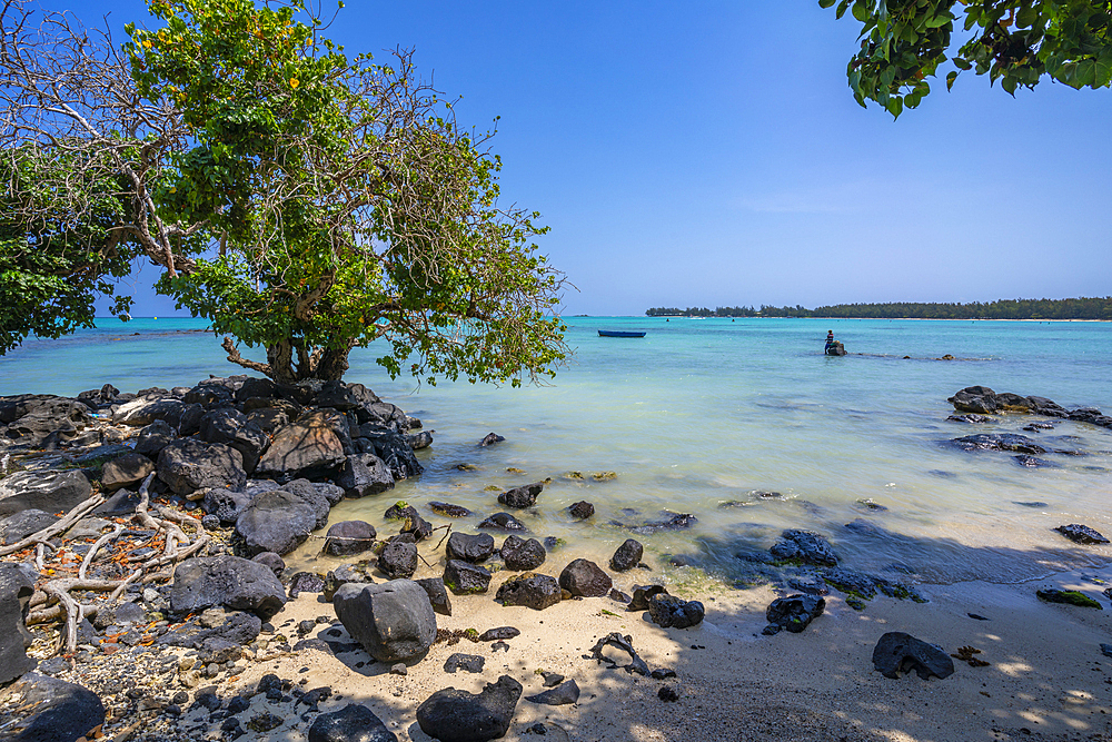 View of man fishing from Mont Choisy Beach and turquoise Indian Ocean on sunny day, Mauritius, Indian Ocean, Africa