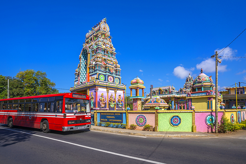 View of red bus and Sri Draubadi Ammen Hindu Temple on sunny day, Mauritius, Indian Ocean, Africa