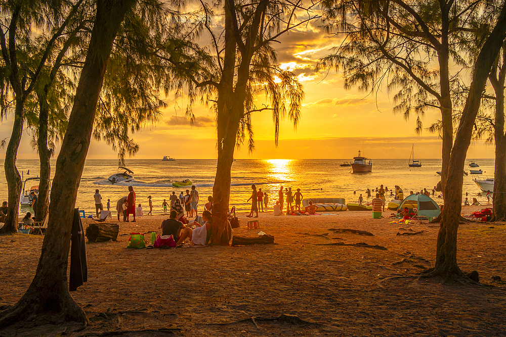 View of trees and people on Mon Choisy Public Beach at sunset, Mauritius, Indian Ocean, Africa