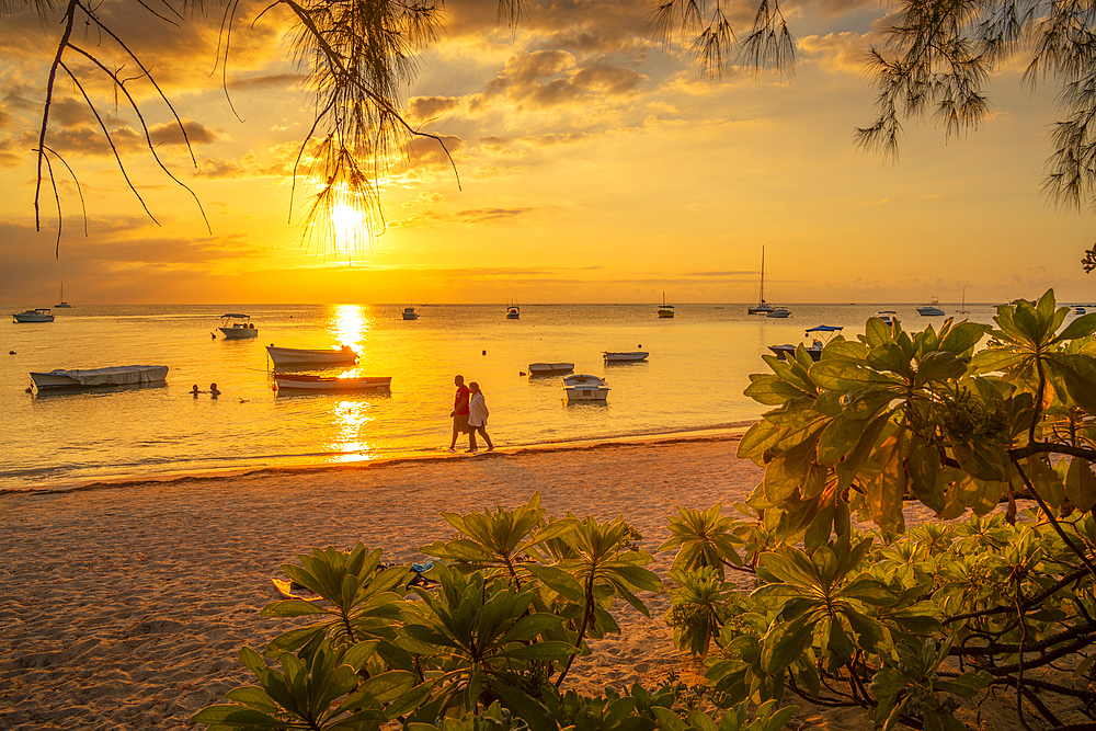 View of boats and people on Mon Choisy Public Beach at sunset, Mauritius, Indian Ocean, Africa