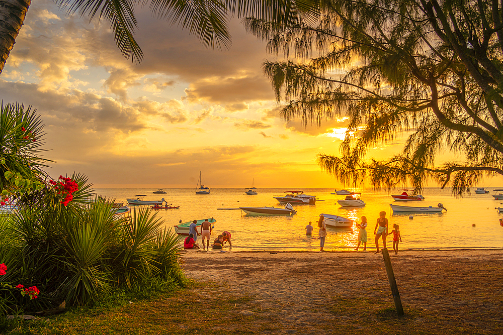 View of boats and people on Mon Choisy Public Beach at sunset, Mauritius, Indian Ocean, Africa