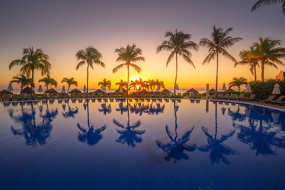 View of sunrise and palm tree reflections in hotel pool near Puerto Morelos, Caribbean Coast, Yucatan Peninsula, Mexico, North America