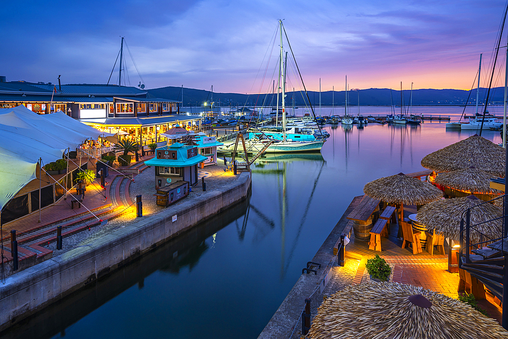 View of boats and restaurants at Knysna Waterfront at dusk, Knysna, Western Cape, South Africa, Africa