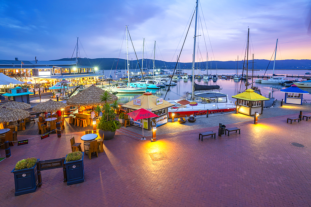 View of boats and restaurants at Knysna Waterfront at dusk, Knysna, Western Cape, South Africa, Africa