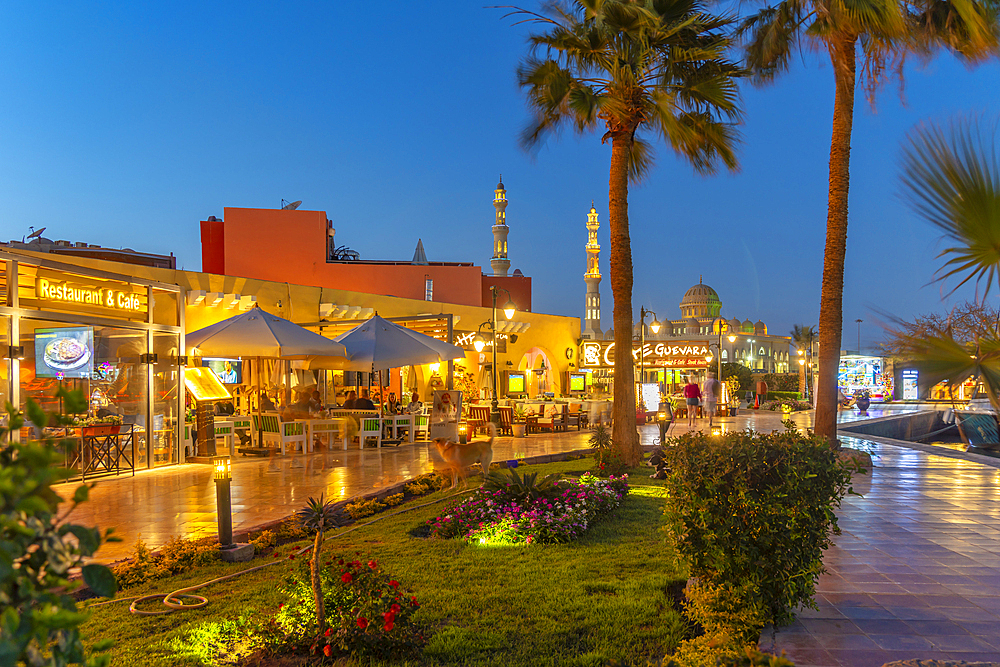 View of cafe and restaurant in Hurghada Marina and Al Mina Mosque in background at dusk, Hurghada, Red Sea Governorate, Egypt, North Africa, Africa