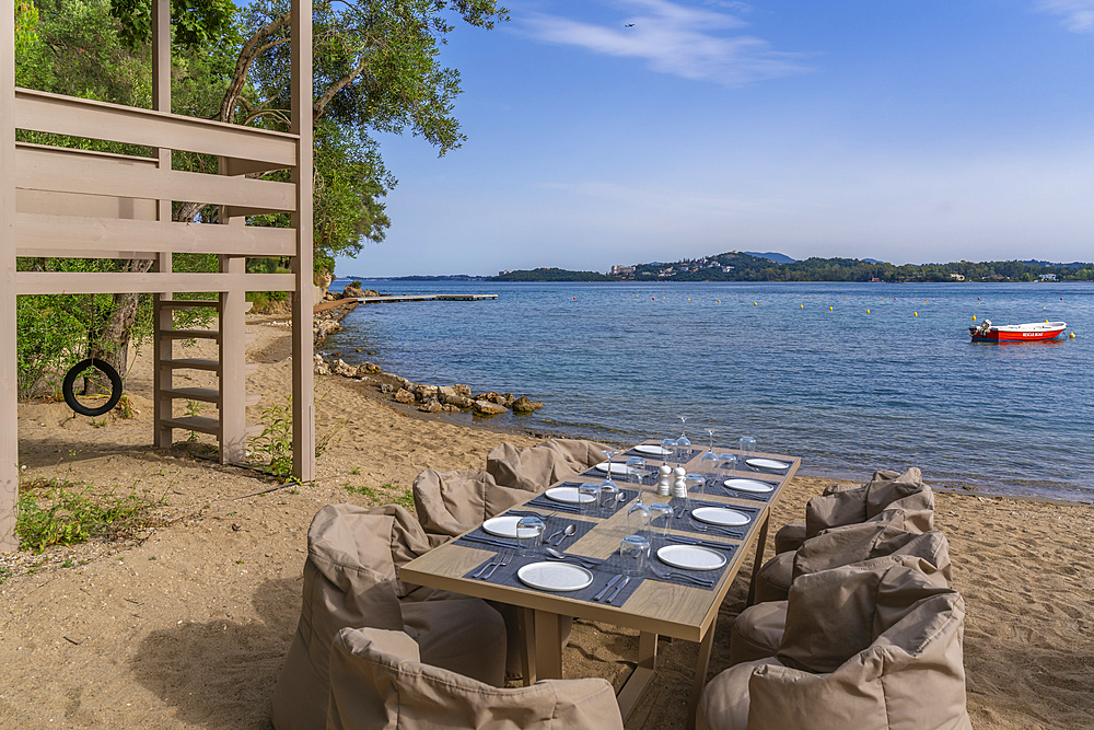 View of alfresco dining table at Dassia Beach and Ionian Sea, Dassia, Corfu, Ionian Sea, Greek Islands, Greece, Europe