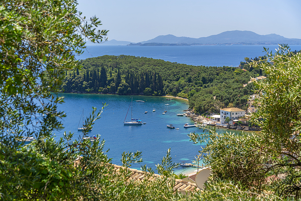 View of boats in the bay at Kalami with Corfu Town in background, Corfu, Ionian Sea, Greek Islands, Greece, Europe