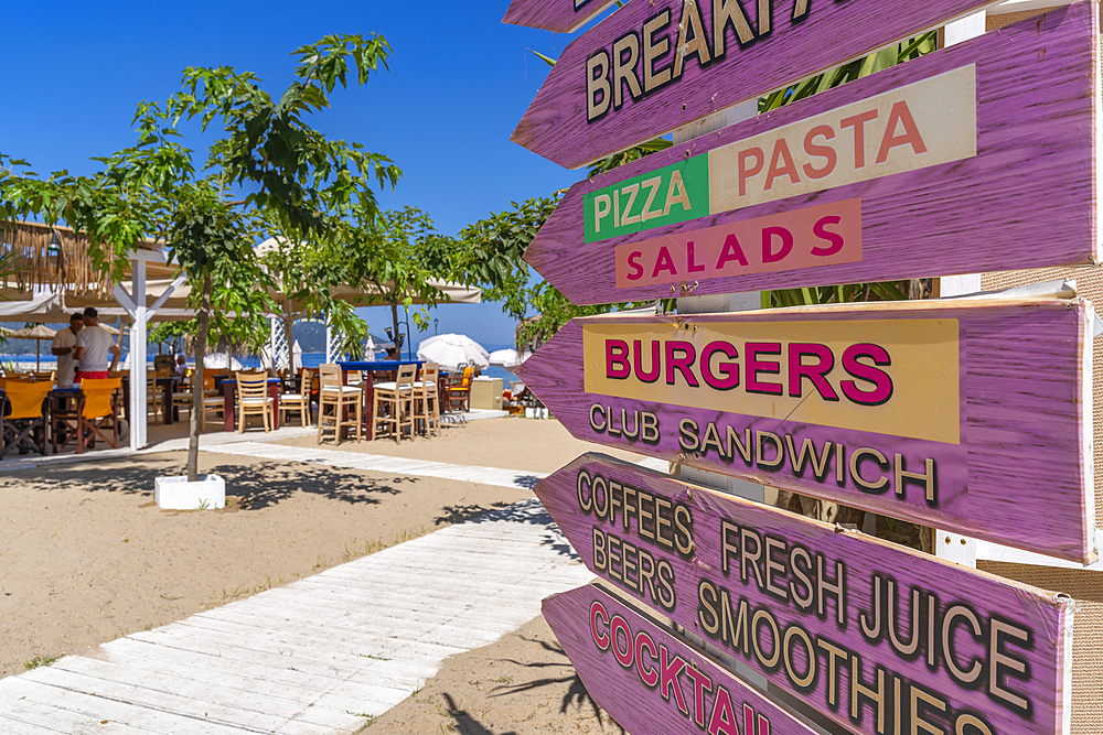 View of restaurant signs and harbour in Thassos Town, Thassos, Aegean Sea, Greek Islands, Greece, Europe