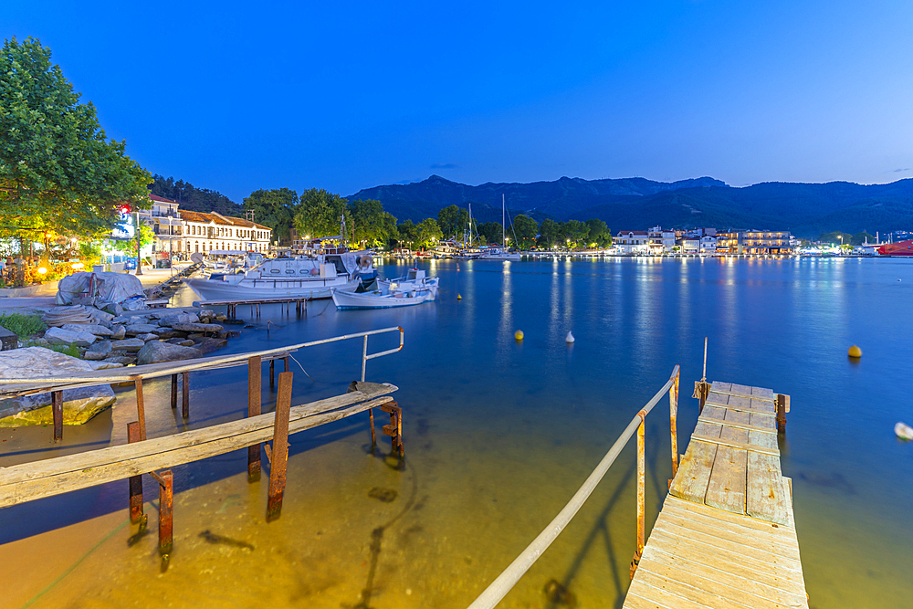 View of boats in old harbour in Thassos Town at dusk, Thassos, Aegean Sea, Greek Islands, Greece, Europe