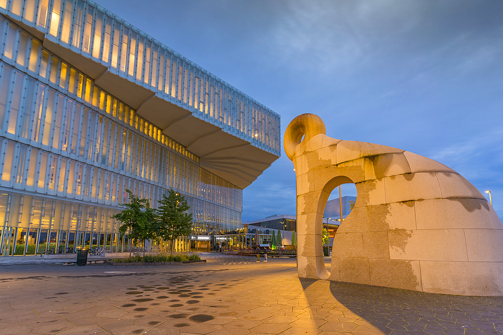 View of Creature from Iddefjord statue and Oslo Central Library on cloudy evening, Oslo, Norway, Scandinavia, Europe