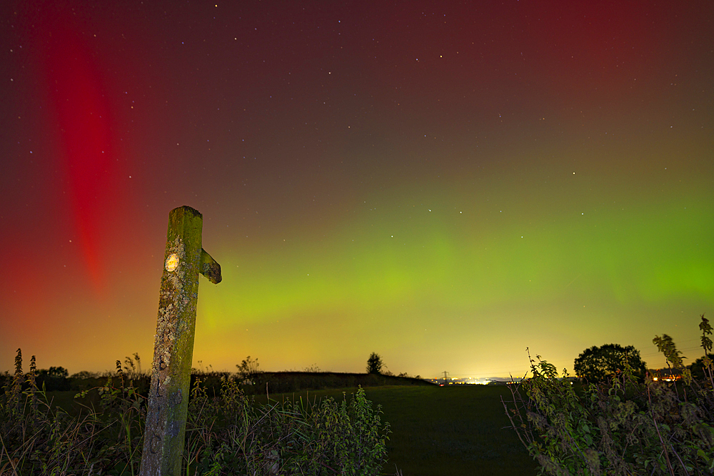 View of Northern Lights (Aurora borealis) and signpost near the village of Glapwell, Bolsover, Derbyshire, England, United Kingdom, Europe