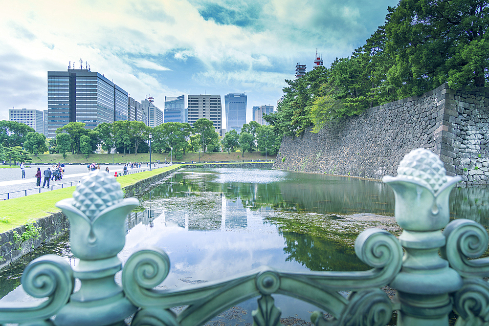 View of city skyline reflecting in the moat of the Imperial Palace of Tokyo, Tokyo, Honshu, Japan