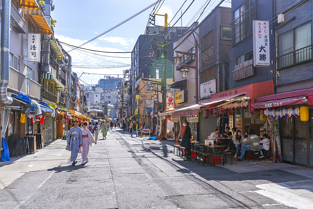 View of couple in traditional Kimono dress, shops and buildings in Asakusa, Taito City, Tokyo, Japan, Asia