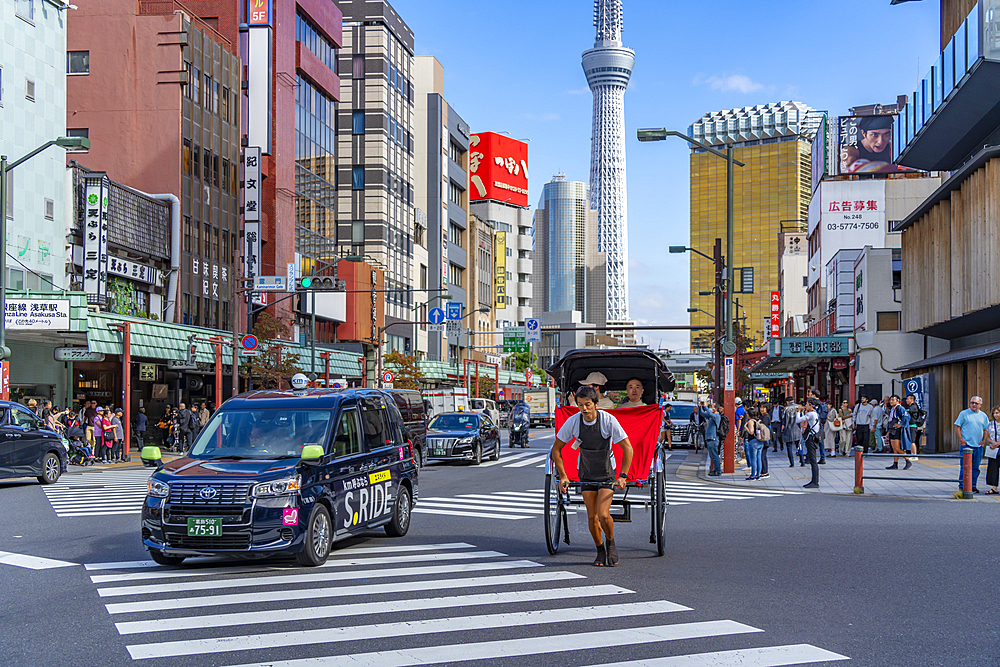 View of Japanese rickshaw or jinrikisha in busy street scene, Asakusa, Taito City, Tokyo, Honshu, Japan