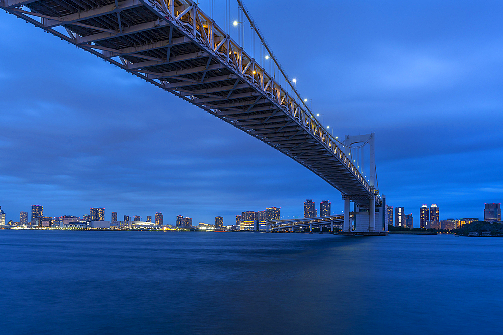 View of the Rainbow Bridge and Koto City in background at dusk, Minato City, Tokyo, Honshu, Japan, Asia