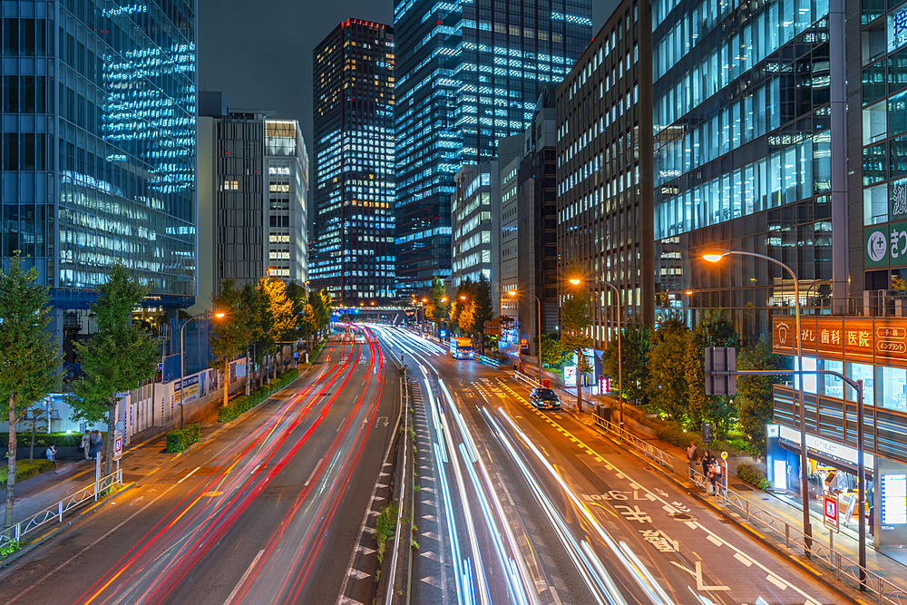 View of city street and trail lights at night, Minato City, Tokyo, Honshu, Japan