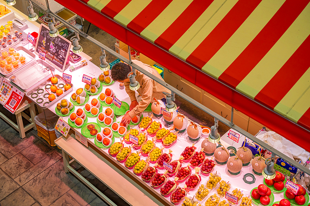 Elevated view of colourful fresh fruit stall and people in Omicho Market, Kanazawa City, Ishikawa Prefecture, Honshu, Japan