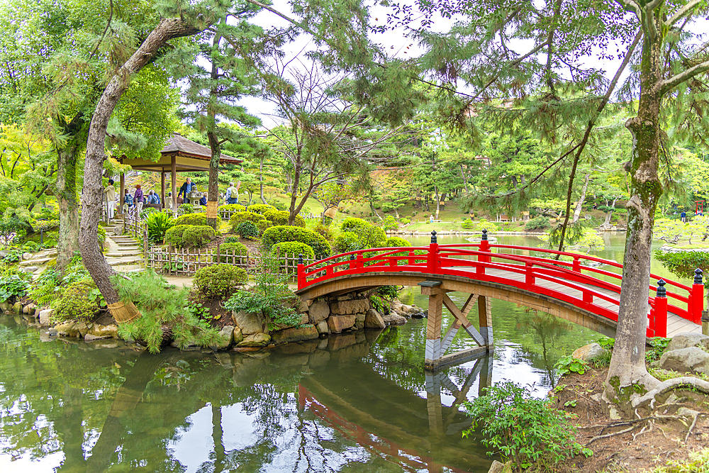 View of red footbridge over Takueichi Pond in Shukkeien Garden, Kaminoboricho, Naka Ward, Hiroshima, Japan, Asia