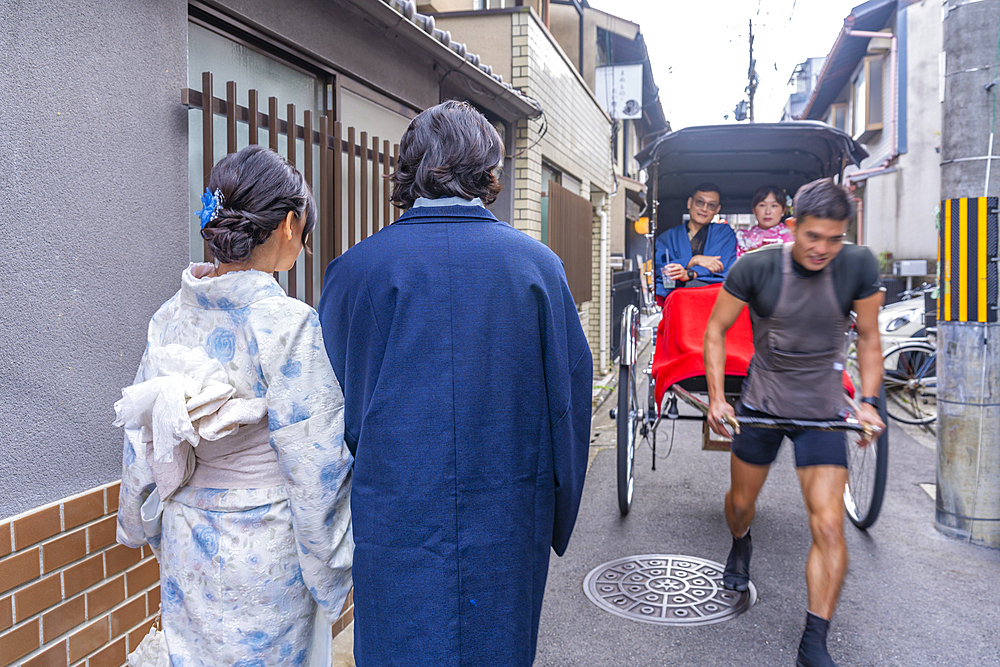 View of couple in Kimonos and rickshaw in Gion, Kyoto’s Geisha District, Kyoto, Japan, Asia