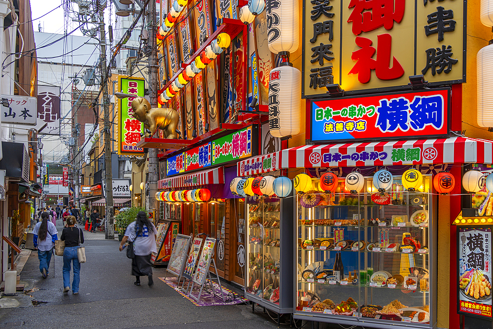 View of colourful facades of shops and restaurants in Dotonbori, vibrant entertainment district near the river, Osaka, Honshu, Japan